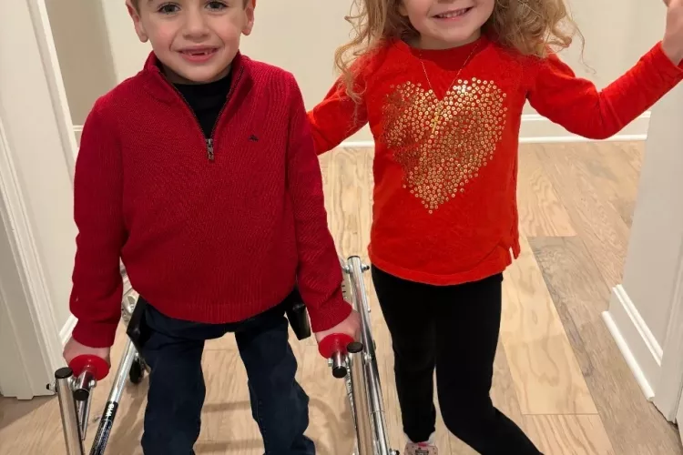 Two children dressed in red standing in a hallway