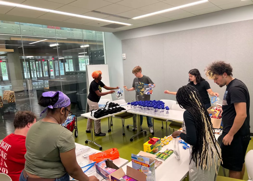 UofL students sort food and other donations at a table.