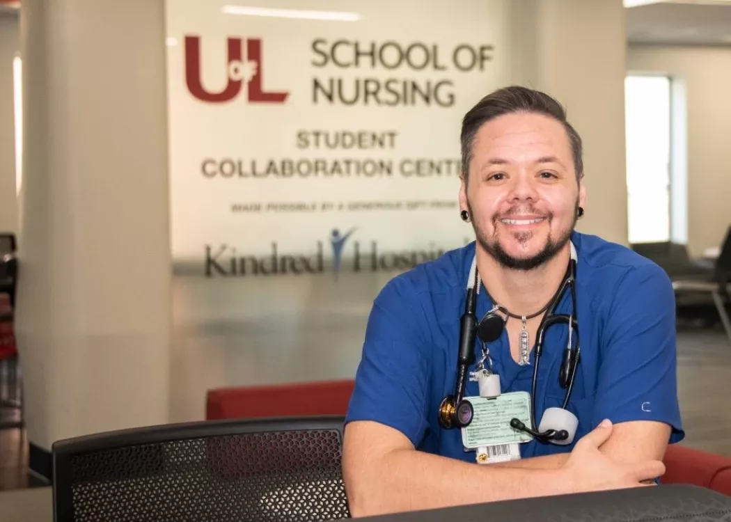 Nursing student posing in front of School of Nursing building