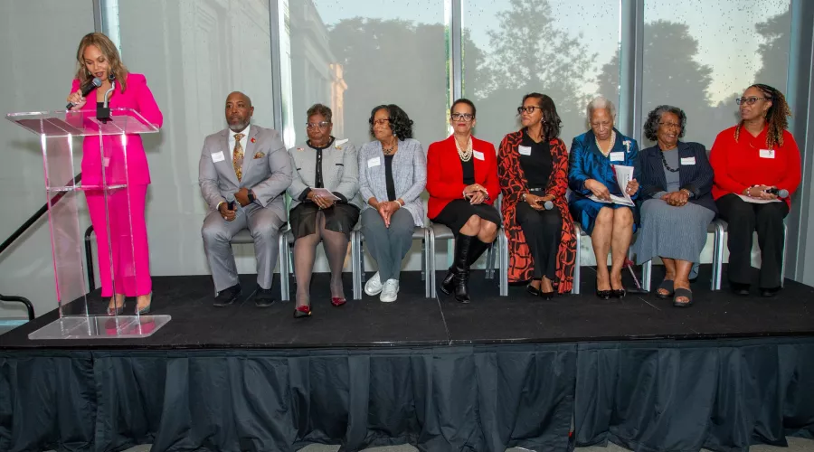 A person speaks at a podium while others listen.