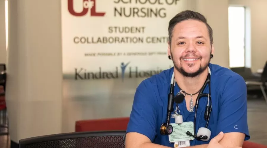 Nursing student posing in front of School of Nursing building